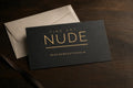 Fine-Art-Nude-Geschenkgutschein mit Umschlag auf einem dunklen Holztisch